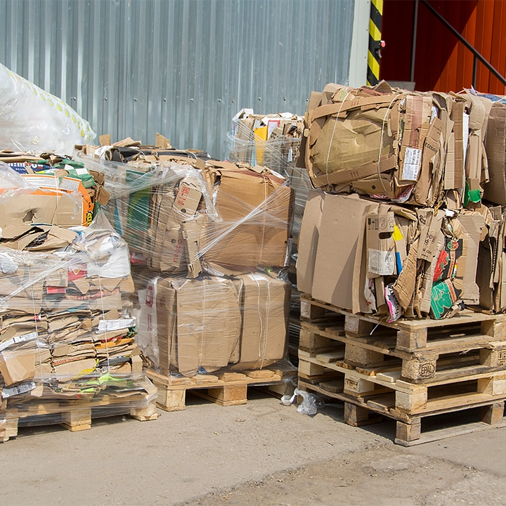 Gepresste Karton- und Papierabfälle auf Paletten – FET transportiert gewerbliche Abfälle sicher, regional und grenzüberschreitend gemäß gesetzlichen Vorschriften.