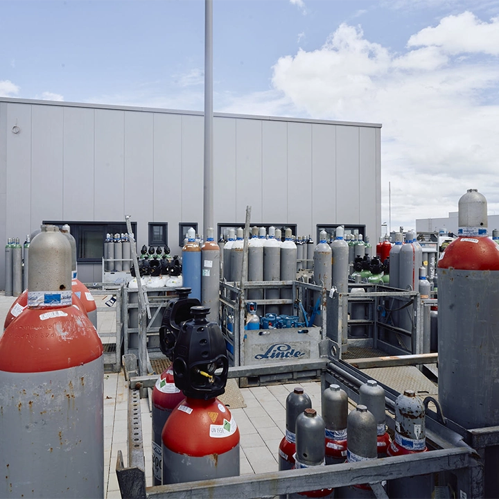 Gasflaschen und Gefahrgutbehälter auf dem Betriebsgelände von FET – spezialisierte Fahrzeuge und geschultes Personal für den sicheren Gefahrguttransport.