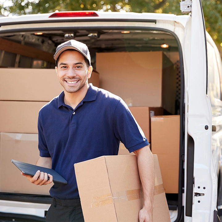 Ein FET Kurierfahrer liefert Pakete aus einem Transporter – zuverlässige Abholung und Zustellung in Deutschland und ganz Europa, rund um die Uhr.